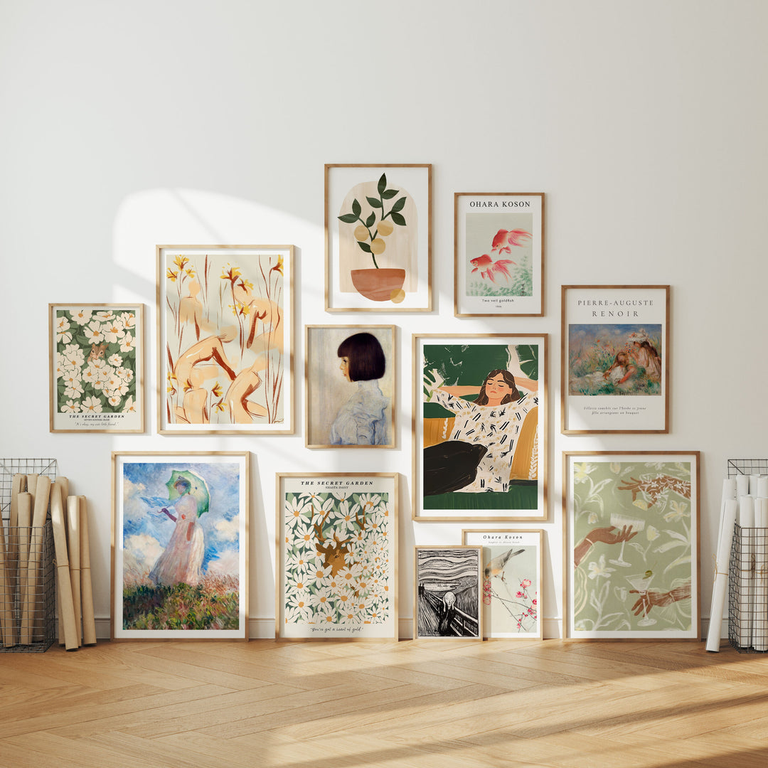 Collection of framed artworks on a wall with a neutral background