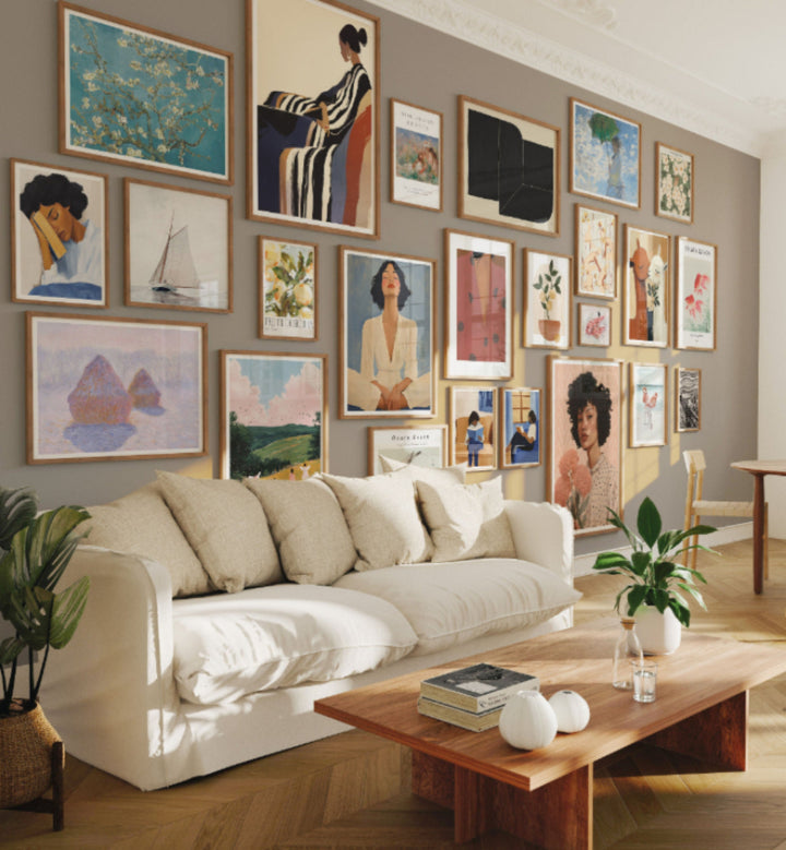 Living room with a beige sofa, wooden coffee table, and wall filled with various framed artworks.